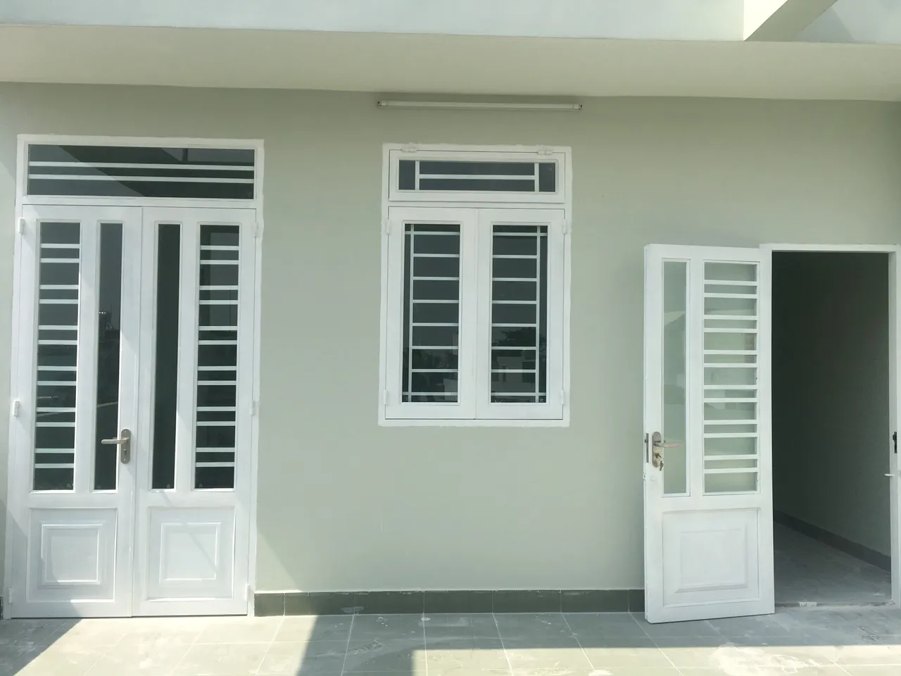 Mẫu cửa sắt 2 cánh đẹp với ô kính và tấm ốp