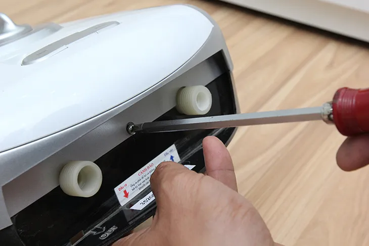 Dùng tua vít tháo mặt nạ của máy nước nóng ra