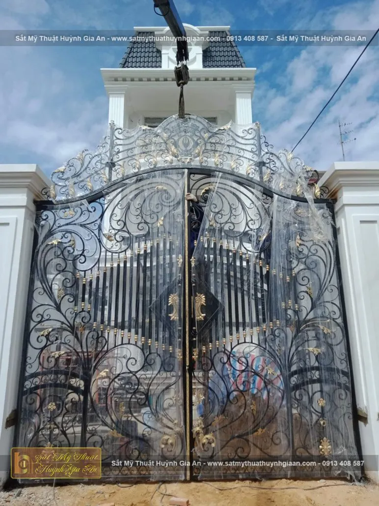 Cổng sắt nghệ thuật với đường nét uốn lượn tinh xảo kèm phụ kiện độc đáo làm nổi bật không gian sống hiện đại