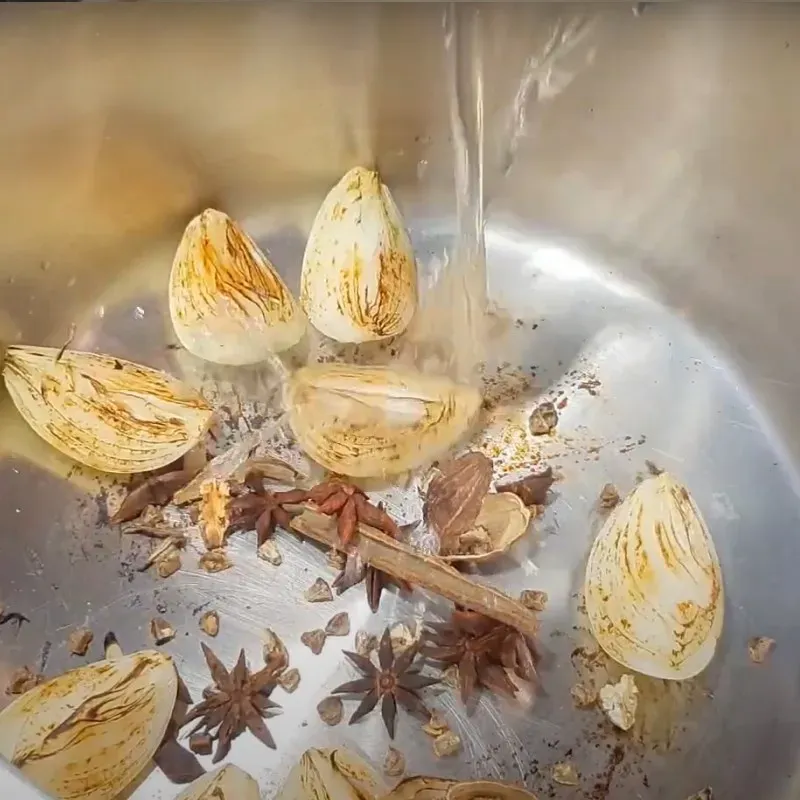 Nồi xương bò đang được ninh liu riu trên bếp, bắp bò và gia vị được xếp gọn gàng, tạo nên vị ngọt đậm đà cho nước dùng phở bò Hà Nội