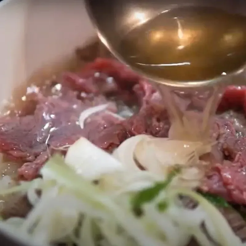 Thưởng thức bát phở bò Hà Nội chuẩn vị với miếng thịt tái hồng hào, nước dùng ngọt thanh, mang đậm tinh hoa ẩm thực Thủ đô