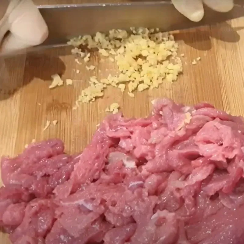 Ướp thịt bò tái với gừng băm, muối, đường, tiêu giúp tăng hương vị và làm mềm thịt trước khi dùng cho phở bò Hà Nội